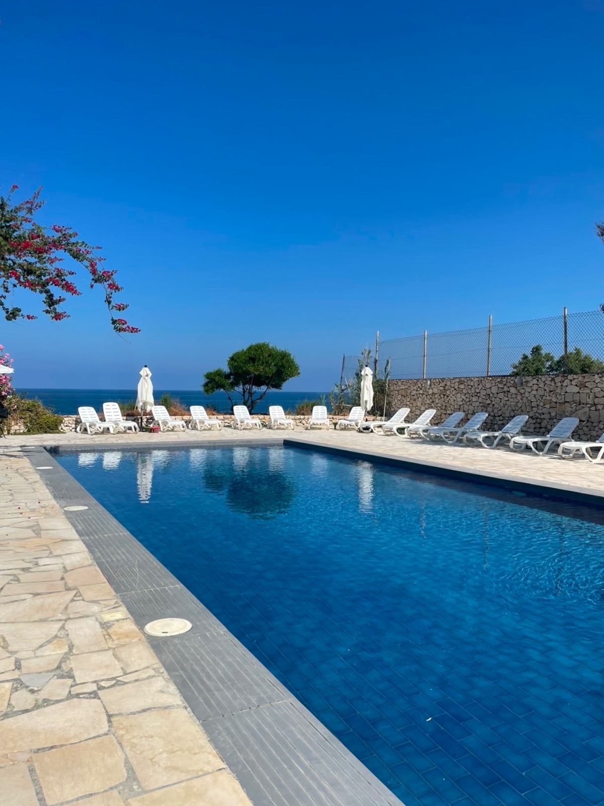 Side B pool with sun loungers and sea view on a clear summer day