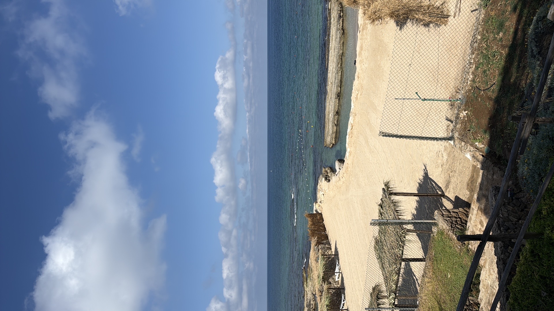 Sandy beach with thatched umbrellas and turquoise sea at Jiyeh
